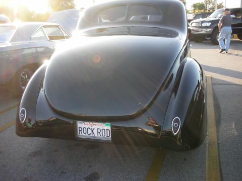 1998 Ford Crown Victoria - Rear view of a black hot rod car with a custom license plate.