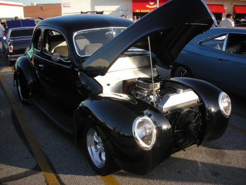 1998 Ford Crown Victoria - Black hot rod coupe with hood open, parked next to another vehicle.