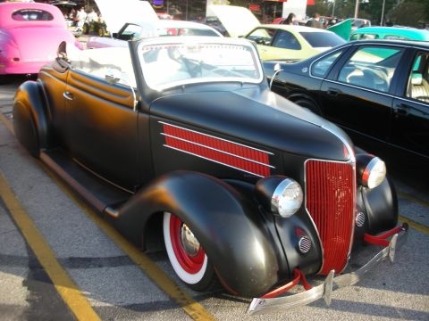 1998 Ford Crown Victoria - A classic black convertible hot rod with distinctive red accents is parked on asphalt, with other vehicles visible in the background.