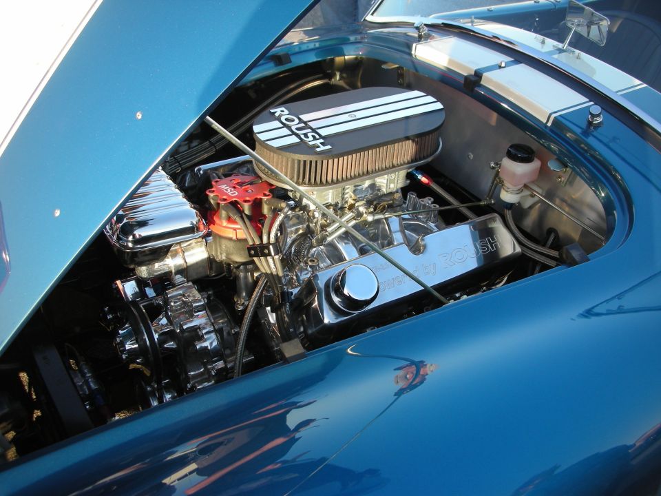 Blue car engine bay with chrome Roush valve covers and air cleaner