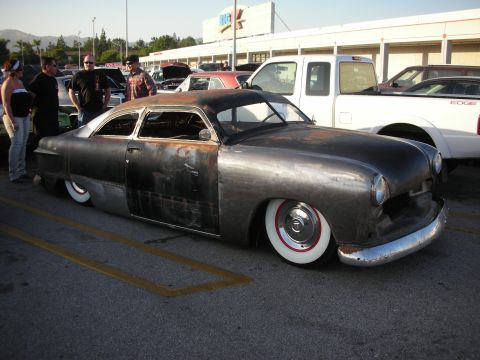 1998 Ford Crown Victoria - Custom hot rod with a raw metal finish and whitewall tires sits low in a parking lot.