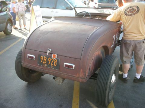 1998 Ford Crown Victoria - Rusty hot rod roadster with a California license plate from 1931.