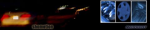 1993 Ford Taurus - A blurry yellow car is seen from the rear at night, with its taillights illuminated.