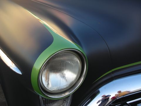 1998 Ford Crown Victoria - Car headlight detail with custom green flame paintwork and chrome accents.