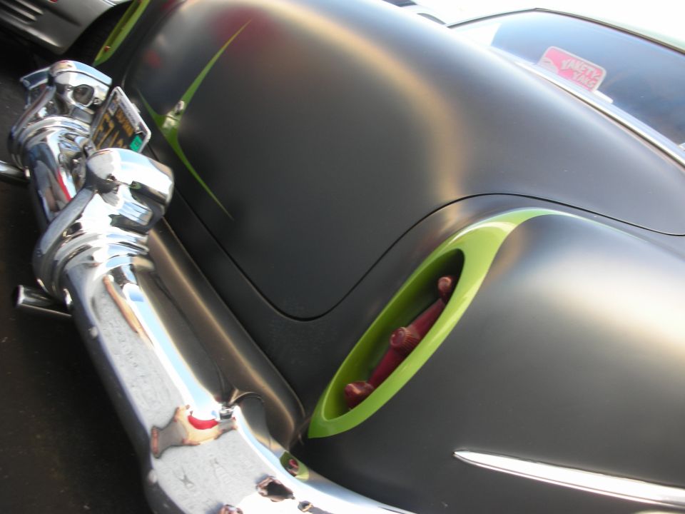 Customized car rear quarter panel with green accents and chrome bumper
