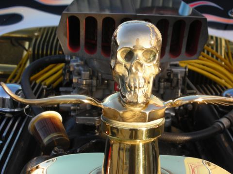 1998 Ford Crown Victoria - A custom hot rod features a prominent gold skull hood ornament and a powerful engine with flame detailing on the body.