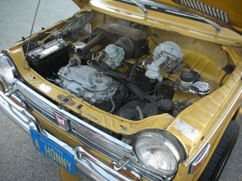 1998 Ford Crown Victoria - The engine bay of a yellow car, a Honda badge on the front grille and a California license plate reading 'A HONNY'.