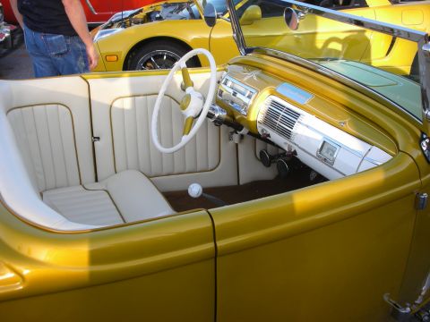 1998 Ford Crown Victoria - The interior of a custom yellow hot rod is shown, with other vehicles in the background.