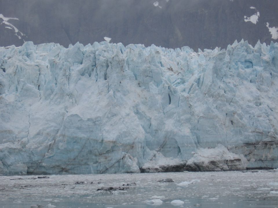 Glacier face with icebergs in foreground water
