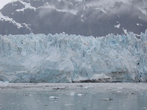 1973 Ford Ranchero - A vast glacier in Alaska, with mountains visible behind it. The water in front is filled with ice chunks.