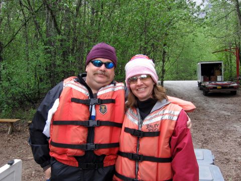 1973 Ford Ranchero - Two people wearing life vests stand outdoors. A trailer is parked behind them in a wooded area.