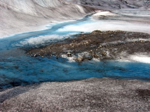 1973 Ford Ranchero - A stream of bright blue meltwater carves a path through a grey and white glacial landscape.
