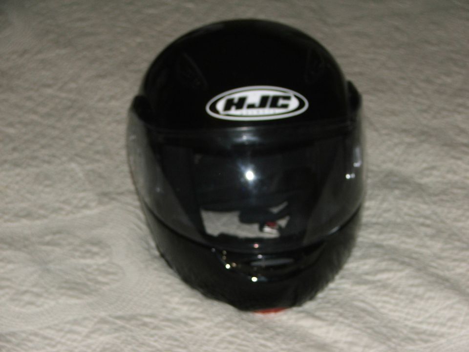 Gloss black HJC full-face motorcycle helmet on white cloth