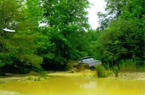 1976 Chevrolet Blazer - A dark colored 1976 Chevrolet Blazer navigates a muddy off-road course, getting stuck in the mire.