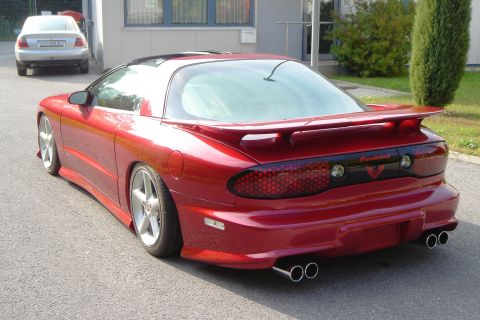 1993 Pontiac Firebird - Rear view of a red 1993 Pontiac Firebird, a prominent spoiler and dual exhaust pipes.