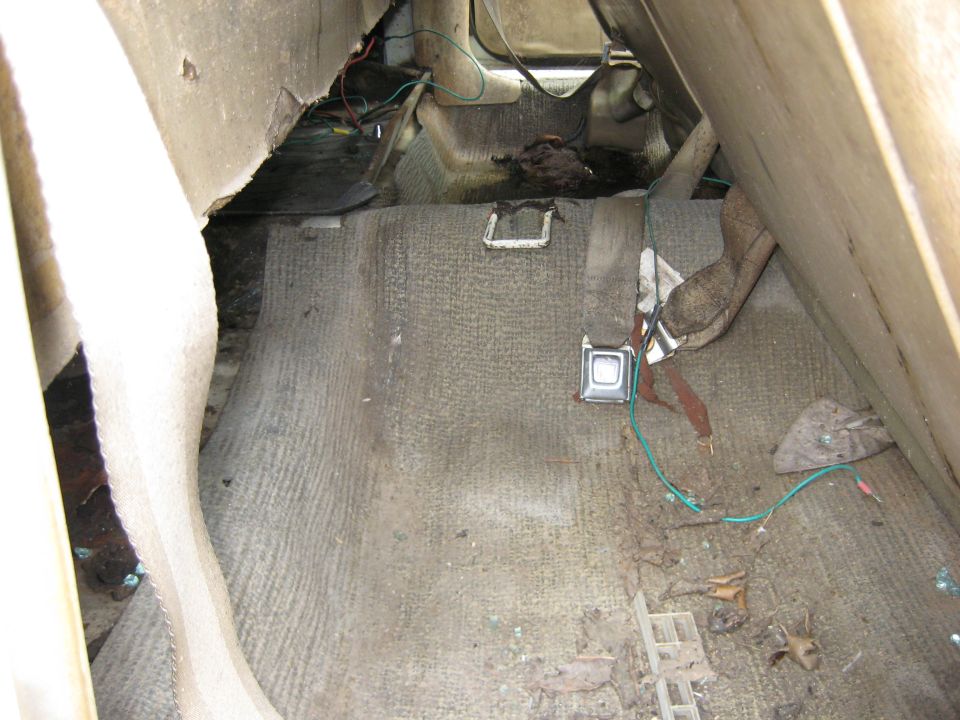 Dirty bare floor pan interior of a stripped vehicle
