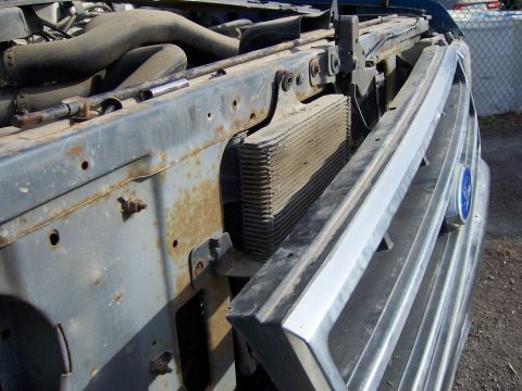 1991 Ford Bronco - Close-up of a 1991 Ford Bronco's engine compartment, showing the radiator and front grille.