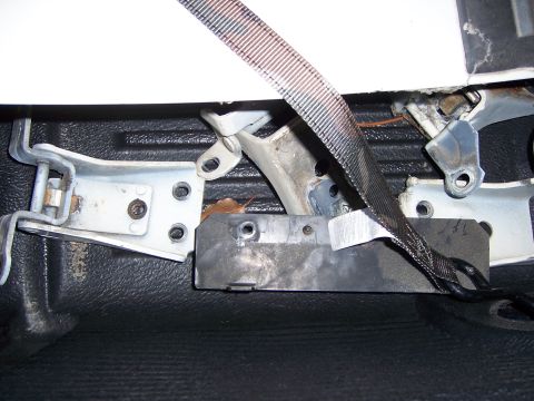 1991 Ford Bronco - Close-up view of a seatbelt anchor and hinge mechanism, likely from a vehicle's interior.