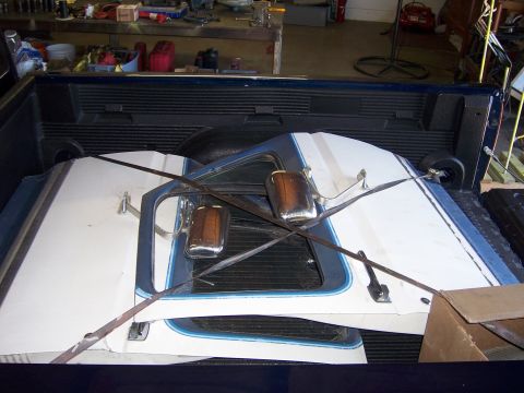 1991 Ford Bronco - Stacked doors and mirrors, possibly from a 1991 Ford Bronco, are loaded into a truck bed.