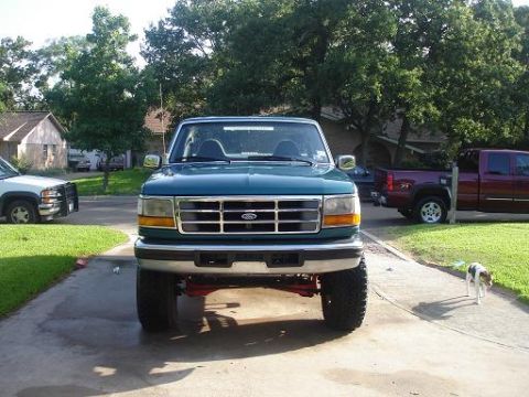 1996 Ford F-150 - Front view of a green 1996 Ford F-150 truck, with another truck parked nearby.