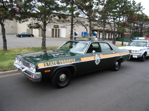1991 Ford LTD Crown Victoria - dark-green State Trooper sedan with gold striping and roof lights is parked along a street next to a white police cruiser.