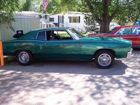 1972 Ford Ranchero - A green 1970 Chevrolet Monte Carlo is parked next to a red car, with mobile homes in the background.