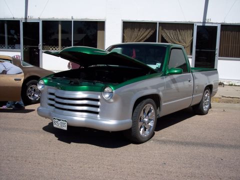 1972 Ford Ranchero - A custom pickup truck with a two-tone silver and green paint scheme is displayed with its hood open, revealing a modified front end.