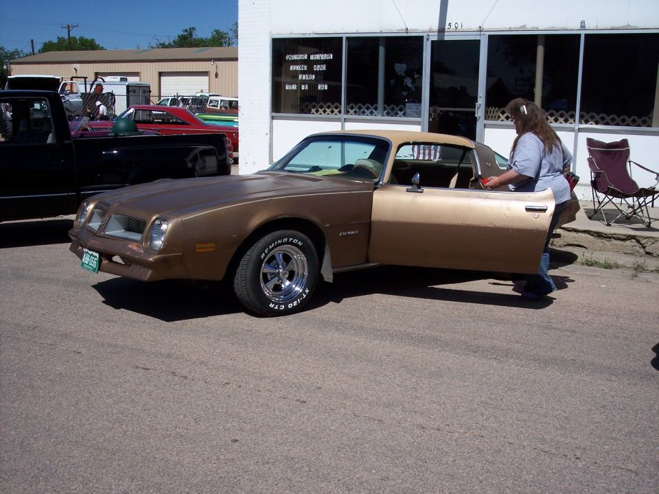 Brown 1977 Pontiac Firebird with door open, parked on asphalt