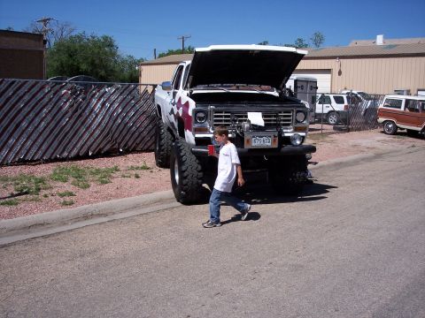 1972 Ford Ranchero - A heavily modified pickup truck with oversized tires and custom paint is parked outside.