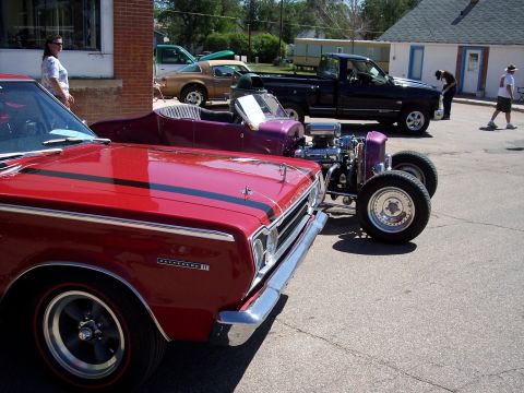 1972 Ford Ranchero - Several vehicles parked outside, including a red car and a purple hot rod with an exposed engine.
