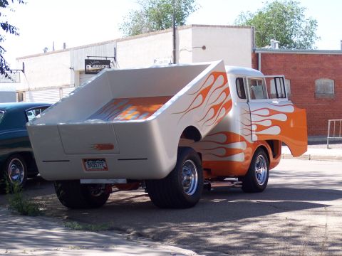 1972 Ford Ranchero - A custom pickup truck with flame graphics is parked on a street next to another vehicle.