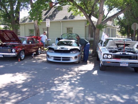 1972 Ford Ranchero - Three cars are parked on a sunny day with their hoods open, suggesting a car show or gathering.