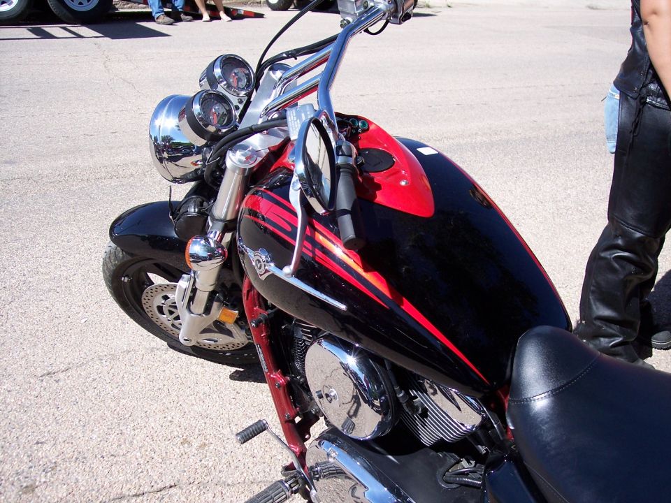 Black and red motorcycle front view, chrome details, handlebars, and seat visible