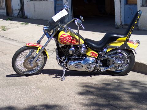 1972 Ford Ranchero - A custom motorcycle with a bright yellow paint job and flame decals is parked on a street.