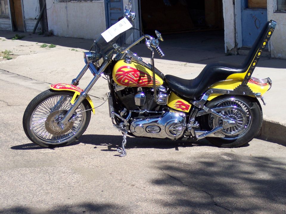 Yellow motorcycle with red flame graphics and a tall backrest on the seat