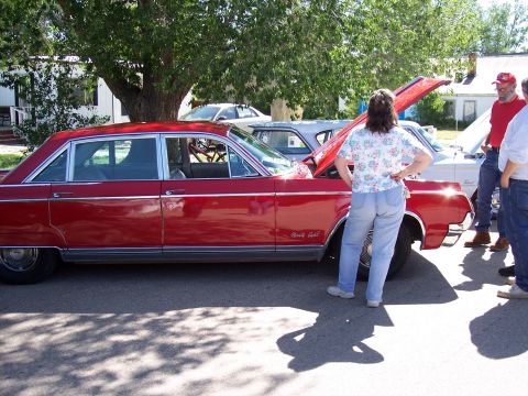 1972 Ford Ranchero - A red Oldsmobile Eighty Eight sedan is displayed with its hood open at a car show.