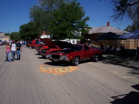 1972 Ford Ranchero - A red 1972 Ford Ranchero is displayed with its hood open at an outdoor car show, alongside other vehicles.