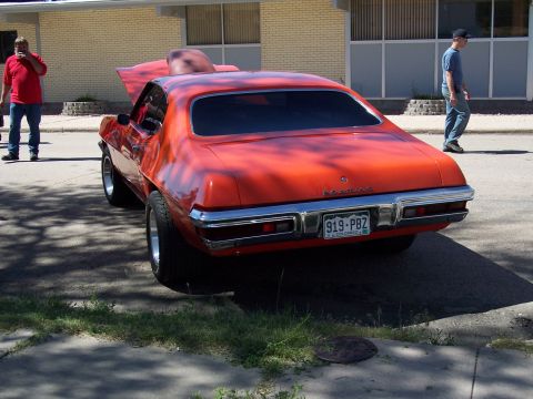 1972 Ford Ranchero - A bright orange 1972 Pontiac Grand Am is shown from the rear, custom paint and a chrome bumper.