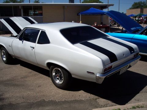 1972 Ford Ranchero - White 1970 Chevrolet Nova with black racing stripes on hood and trunk, parked next to a blue car.