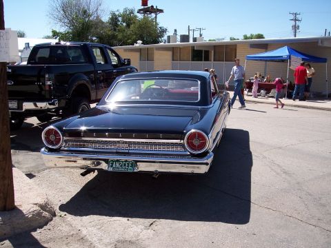 1972 Ford Ranchero - A classic black Ford Galaxie is parked at an outdoor event with people milling around.