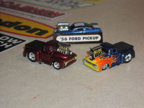 1981 Ford Bronco - Two custom toy pickup trucks are displayed, one with a metallic maroon finish and the other with a flame paint job.