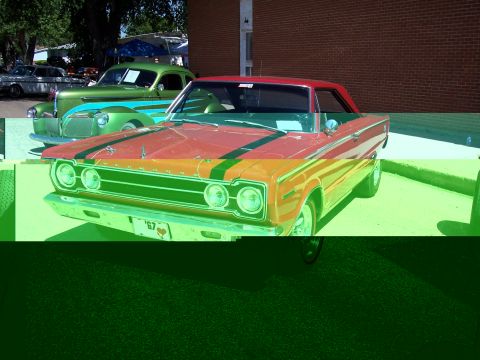1972 Ford Ranchero - A red car with green racing stripes is parked next to a teal and green vintage car.