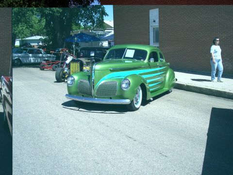 1972 Ford Ranchero - A custom green coupe with teal racing stripes is displayed at an outdoor event.