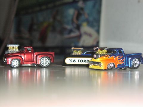 1981 Ford Bronco - Two custom toy trucks, one red and one blue with flames, are displayed side-by-side.