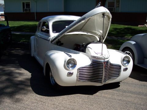 1972 Ford Ranchero - Front view of a white 1940s Chevrolet coupe with its hood open, parked outdoors.