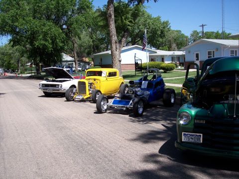 1972 Ford Ranchero - Several custom vehicles are lined up on a street under a clear blue sky.