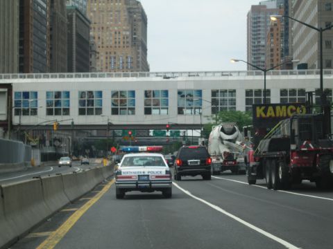 1991 Ford LTD Crown Victoria - North Haven Police sedan drives in city traffic alongside a cement mixer and a red flatbed truck labeled KAMCO.