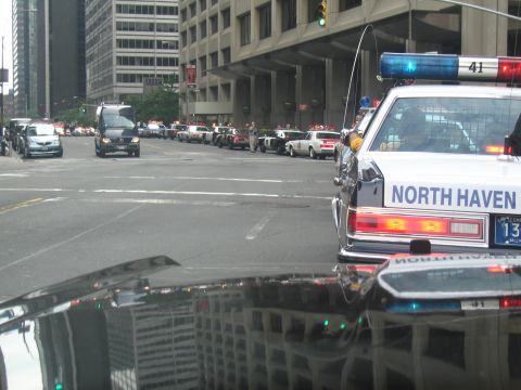 1991 Ford LTD Crown Victoria - North Haven Police sedan sits in the foreground as numerous police cars line a downtown street near office towers.