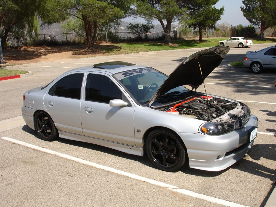 Silver sedan with hood open, SVT banner on windshield, black rims