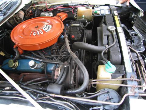 1991 Ford LTD Crown Victoria - classic car engine bay with an orange 440-labeled air cleaner, blue valve cover, belts and a yellow washer reservoir.